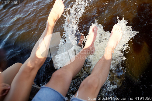 Image of legs of couple splashing water in river