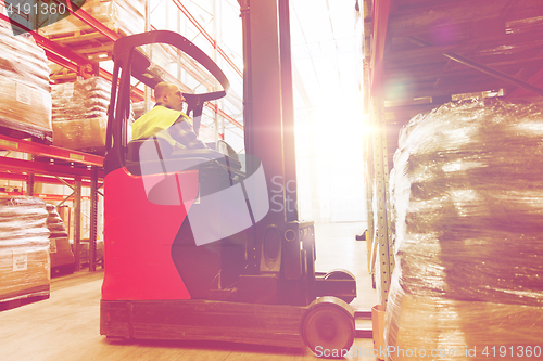 Image of man on forklift loading cargo at warehouse