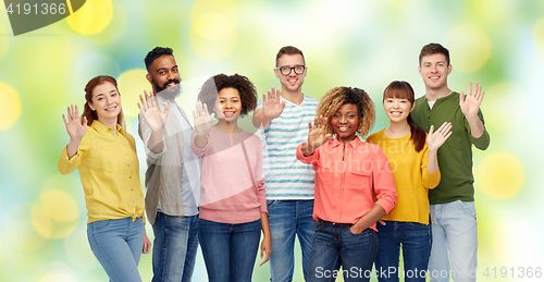 Image of international group of happy people waving hand