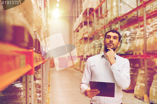 Image of businessman with clipboard at warehouse