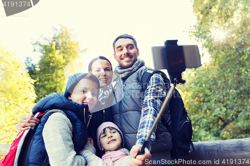 Image of family with backpacks taking selfie and hiking