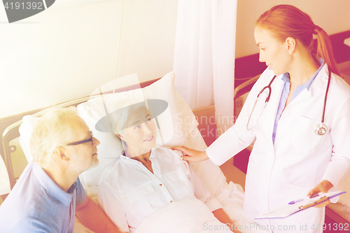 Image of senior woman and doctor with clipboard at hospital