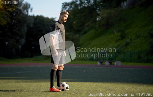 Image of soccer player playing with ball on football field