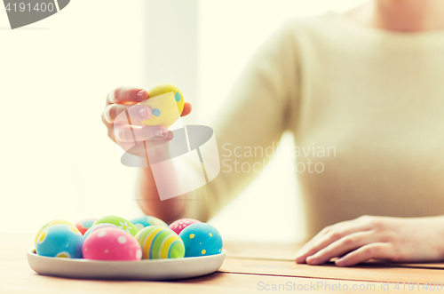 Image of close up of woman hands with colored easter eggs