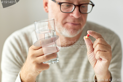 Image of close up of hands with medicine pills and water