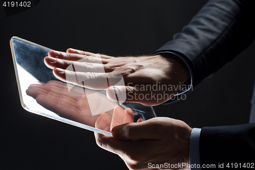 Image of close up of businessman with transparent tablet pc