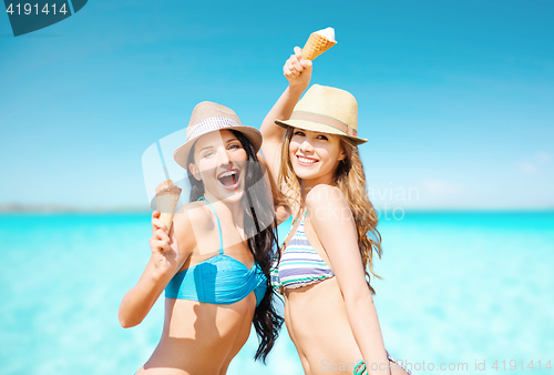 Image of smiling women eating ice cream on beach