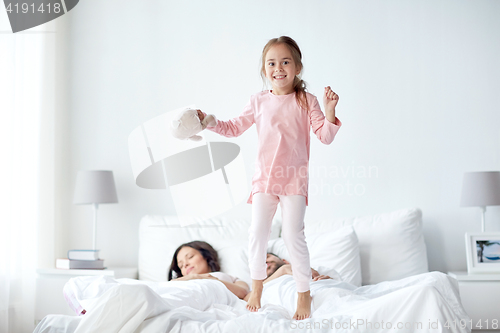 Image of happy child with toy and parents in bed at home