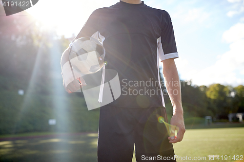 Image of close up of soccer player with football on field