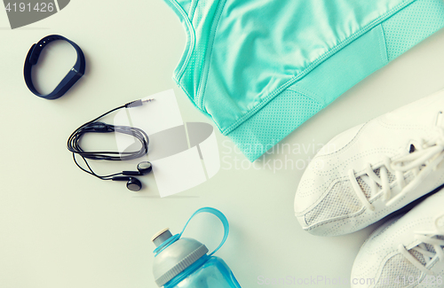 Image of sportswear, bracelet, earphones and bottle set