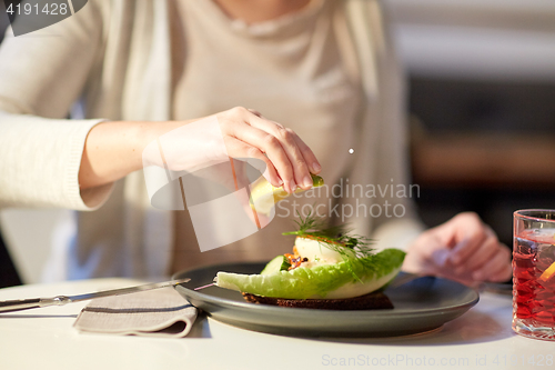 Image of woman eating caviar salad at cafe or restaurant