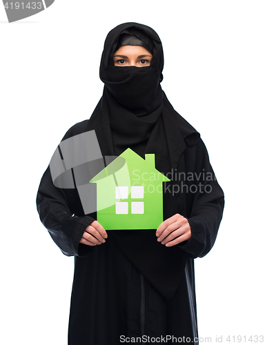 Image of muslim woman in hijab with green house over white