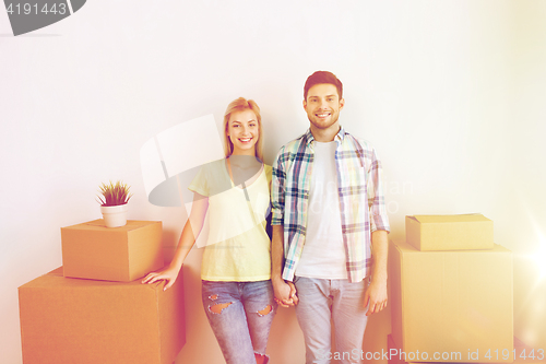 Image of smiling couple with big boxes moving to new home