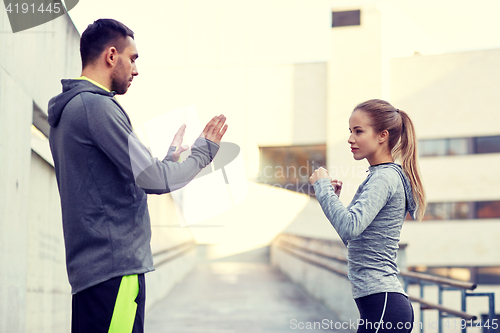 Image of woman with coach working out strike outdoors