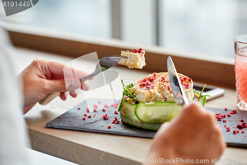 Image of woman eating goat cheese salad at restaurant