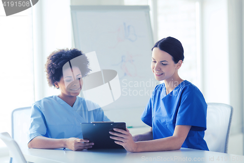 Image of happy doctors with tablet pc meeting at hospital