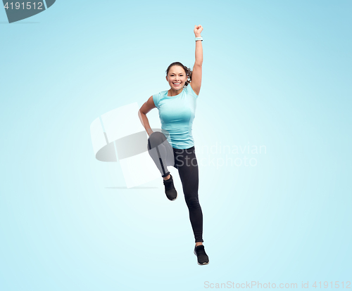 Image of happy smiling sporty young woman jumping in air