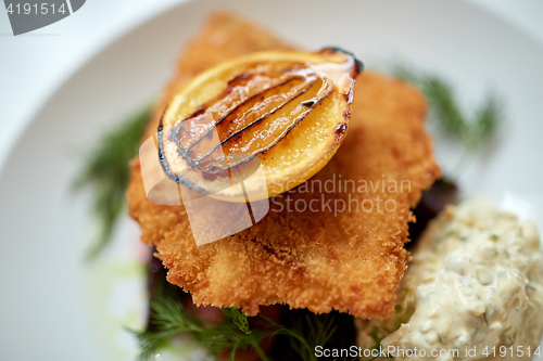 Image of close up of fish salad with roasted lemon on plate