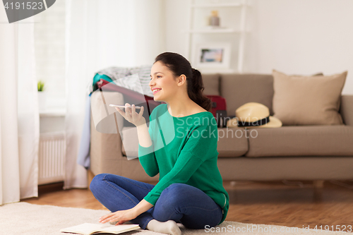 Image of woman with smartphone and travel map at home