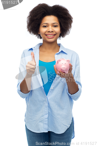 Image of happy woman with piggy bank showing thumbs up