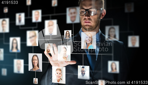 Image of businessman touching screen with contact icons