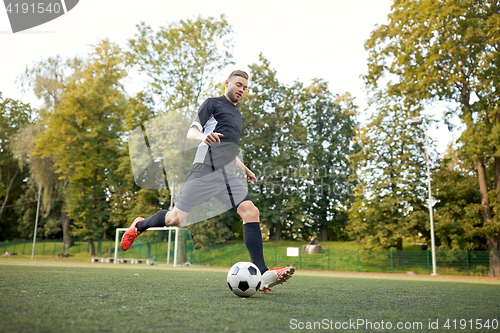 Image of soccer player playing with ball on football field