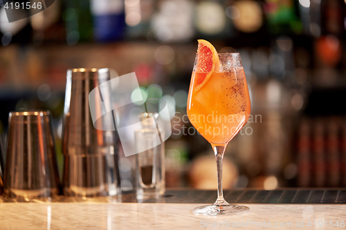 Image of glass of grapefruit cocktail at bar