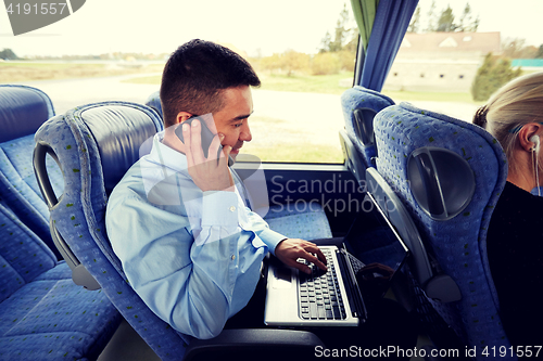 Image of man with smartphone and laptop in travel bus