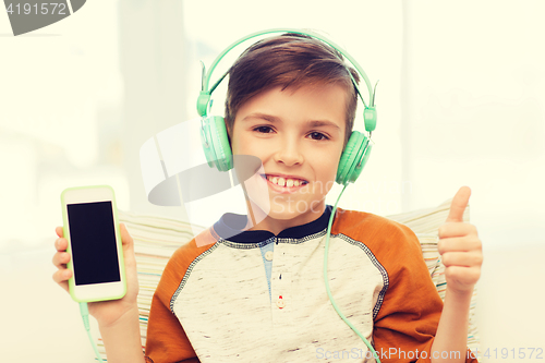 Image of happy boy with smartphone and headphones at home