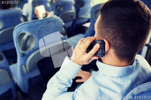 Image of man with smartphone and laptop in travel bus