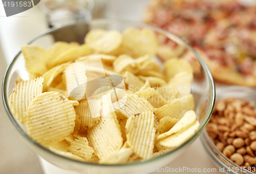Image of close up of crunchy potato crisps in glass bowl