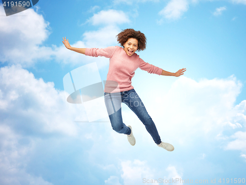 Image of happy african american woman jumping over white