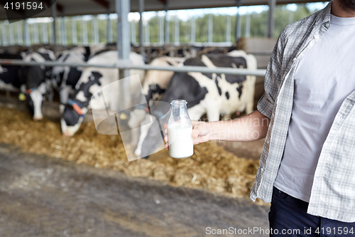 Image of close up of man or farmer with milk on dairy farm