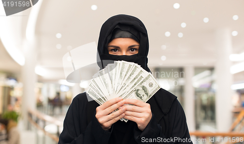 Image of muslim woman in hijab with money over white