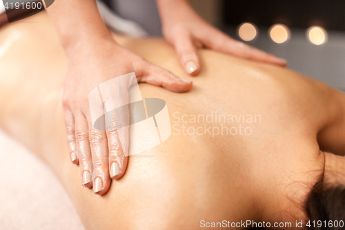 Image of woman lying and having back massage at spa