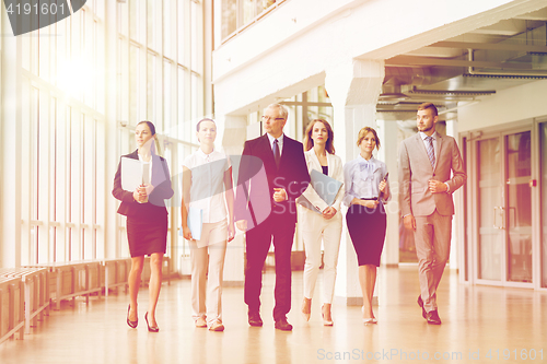 Image of business people walking along office building