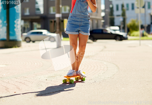 Image of teenage girl riding skateboard on city street