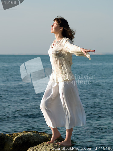 Image of Young barefoot Lady Stays on Stone arms outstretched