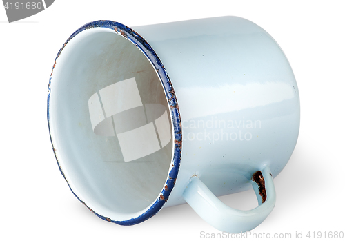 Image of Old worn enameled mug lying