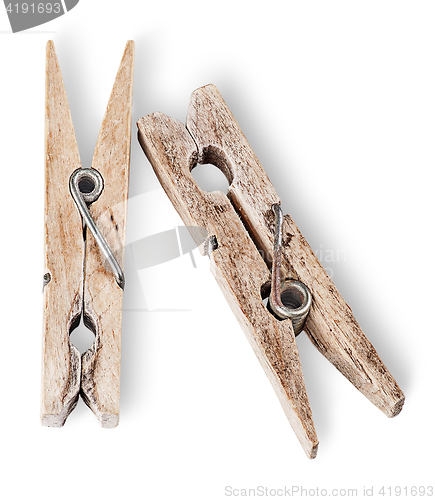Image of Two old wooden clothespins beside