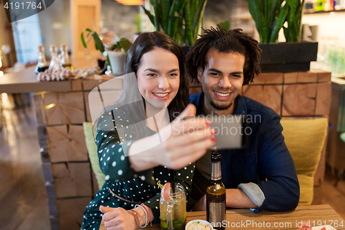 Image of happy couple taking selfie at cafe or bar