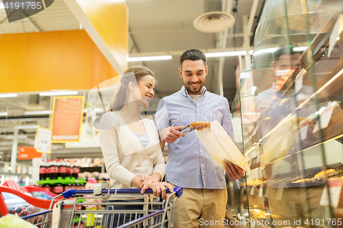 Image of happy couple with shopping cart at grocery store