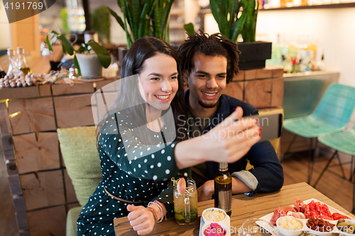 Image of happy couple taking selfie at cafe or bar