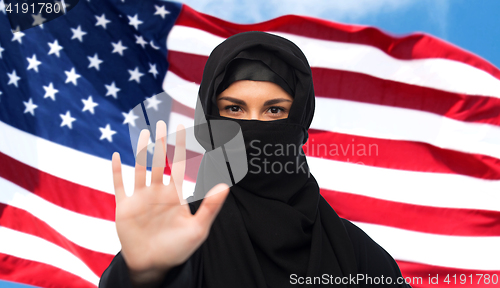 Image of muslim woman in hijab showing stop sign