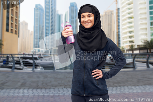 Image of muslim woman with water bottle doing sport