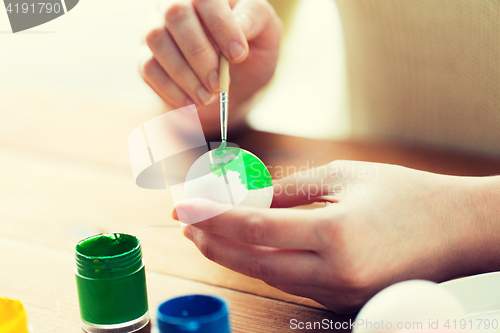 Image of close up of woman hands coloring easter eggs