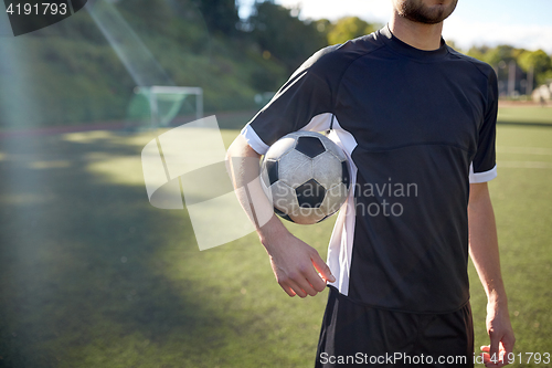 Image of close up of soccer player with football on field