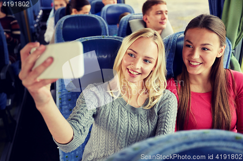 Image of women taking selfie by smartphone in travel bus