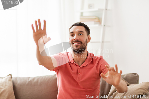 Image of happy man touching something imaginary at home