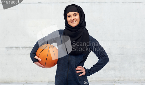 Image of happy muslim woman in hijab with basketball